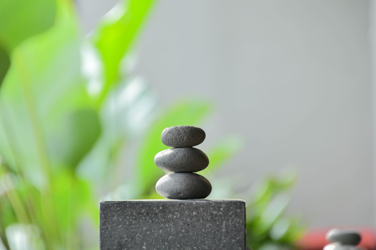 Peaceful zen garden scene with stacked stones and lush greenery background in Bali, Indonesia.